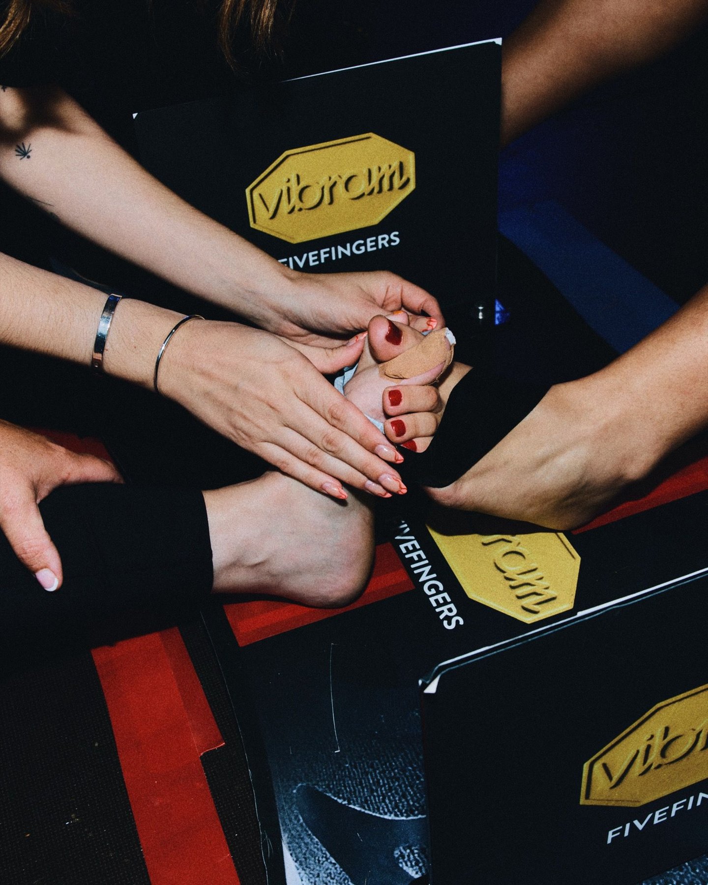 TWC competitor's taped foot resting on Vibram FiveFingers boxes